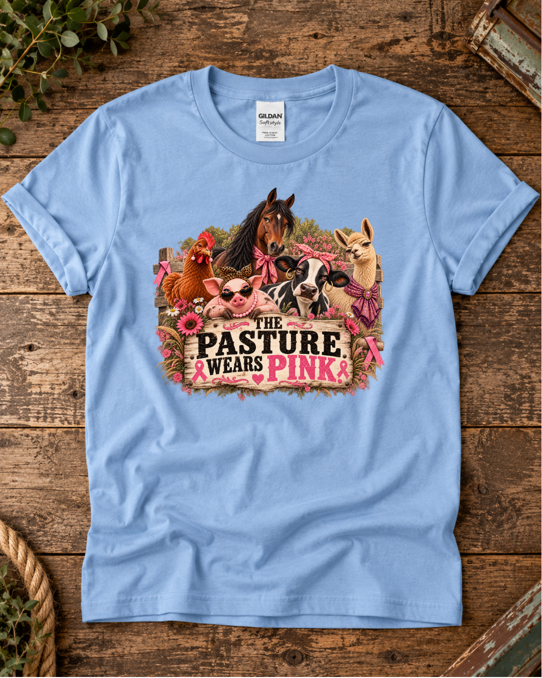Light blue Pasture Wears Pink breast cancer awareness T-shirt featuring the colorful farm-animal herd in pink accessories.